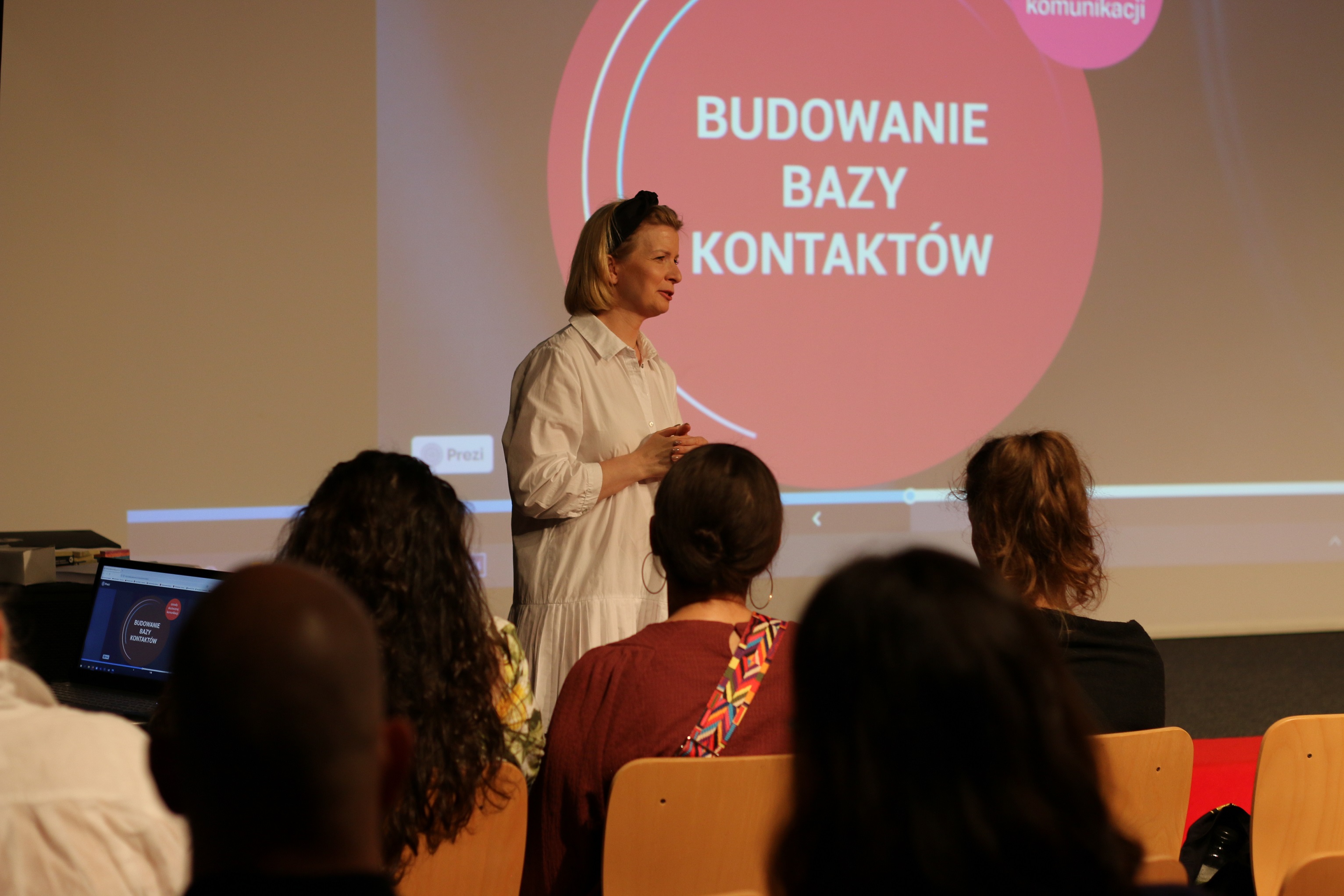 Katarzyna Supeł-Zaboklicka podczas prowadzenia szkolenia. W tle prezentacja z napisem: Budowanie bazy kontaktów. 