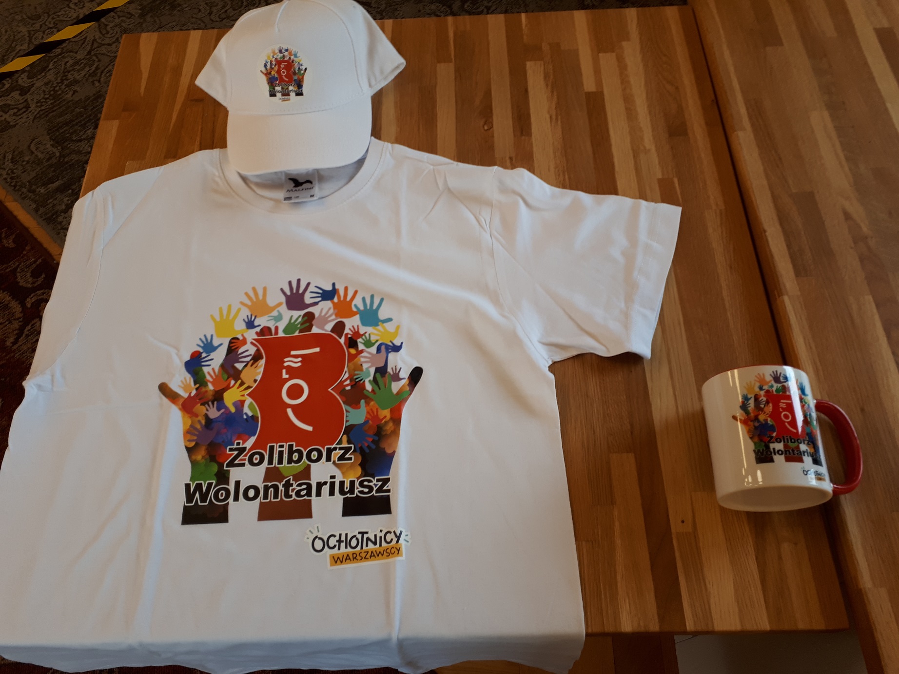 Materiały identyfikacyjne dla wolontariuszy - koszulka, czapka z daszkiem i kubek