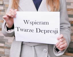 Dłonie trzymające kartkę z napisem: "Wspieram Twarze Depresji".