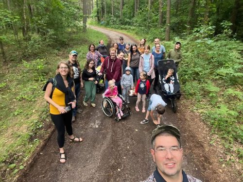 Grupa ponad 20 osób na spacerze leśnym w letni dzień