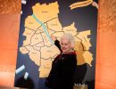 Starsza kobieta wskazująca na mapie Warszawy wybraną dzielnicę