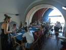 Sala warsztatowa, w której zgromadzeni są uczestnicy i uczestniczki warsztatu z makramy.