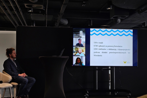 Zdjęcie przedstawia ekran, na którym widoczne jest spotkanie online z uczestnikami konferencji.