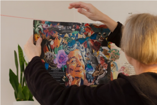 Wolontariuszka wieszająca kolorową grafikę z portretem Wisławy Szymborskiej