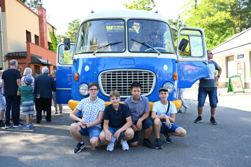 Zdjęcie prezentujące grupkę wolontariuszy na tle zabytkowego autobusu