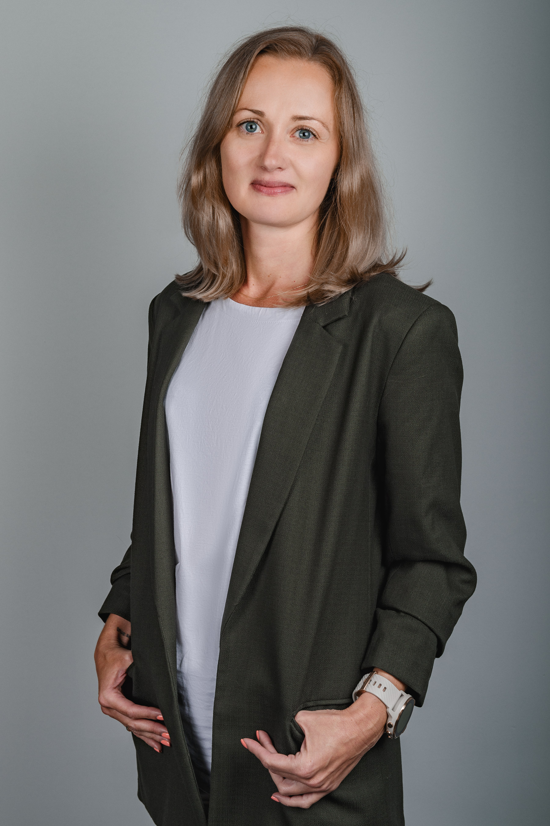 Marta Marchlewska-Ziomek w czarnej marynarce na szarym tle