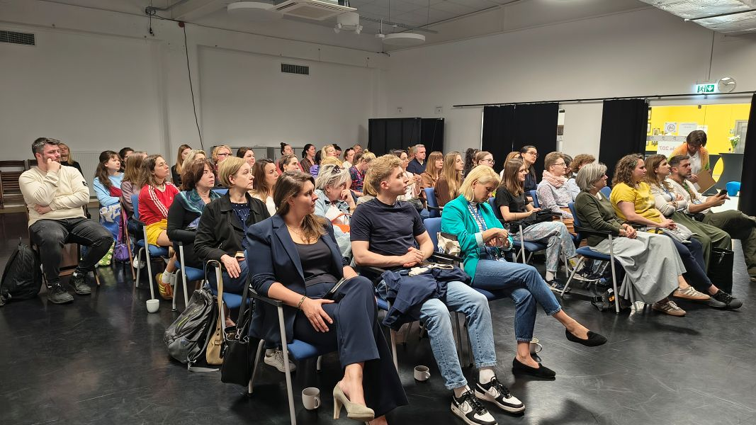 Uczestnicy i uczestniczki konferencji słuchają prelekcji.