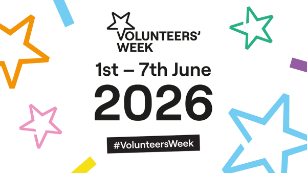 Czarny napis Volunteers Week 2026 na białym tle. Wokół napisu kolorowe gwiazdki. 