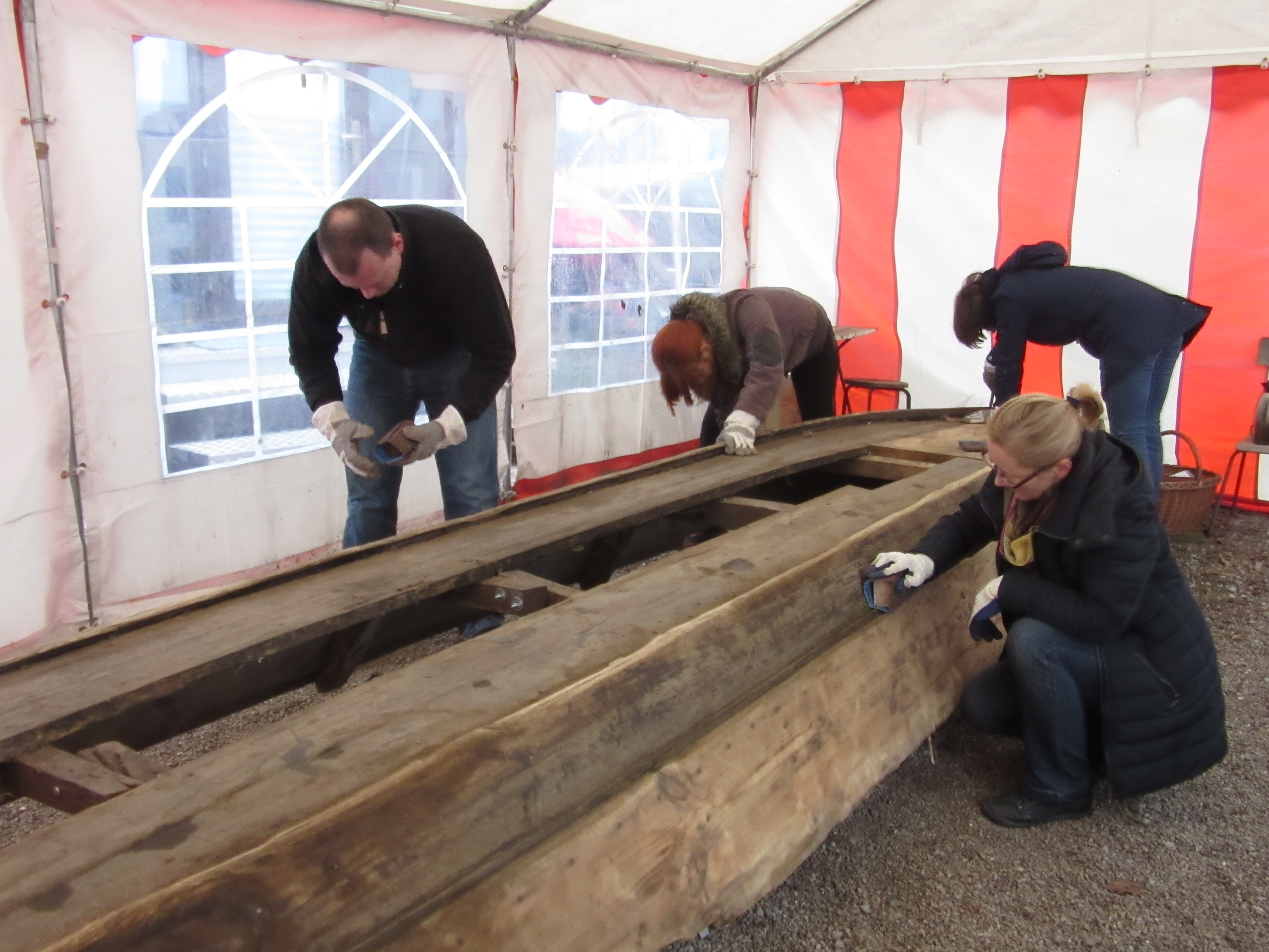 Wolontariusze remontujący łódź w namiocie