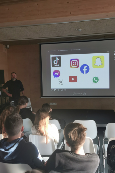 Uczestnicy i uczestniczki zgromadzeni w sali podczas warsztatów "bezpieczni w sieci"