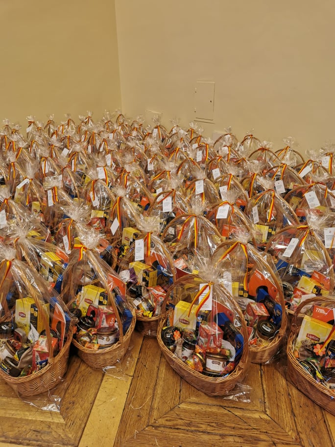Kilkadziesiąt koszy upominkowych w folii ochronnej stojących na podłodze