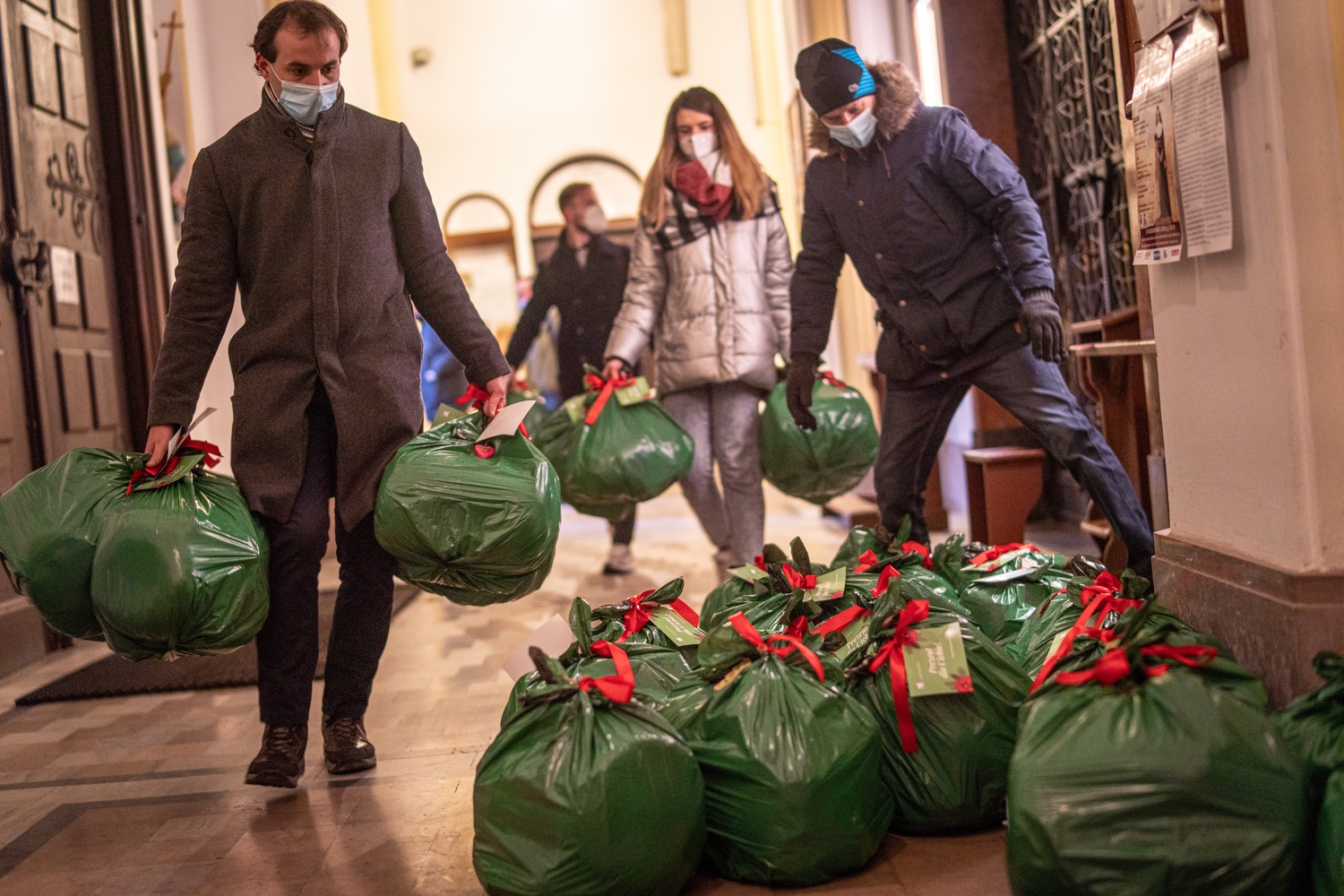 Wolontariusze układają worki z podarunkami świątecznymi dla osób bezdomnych