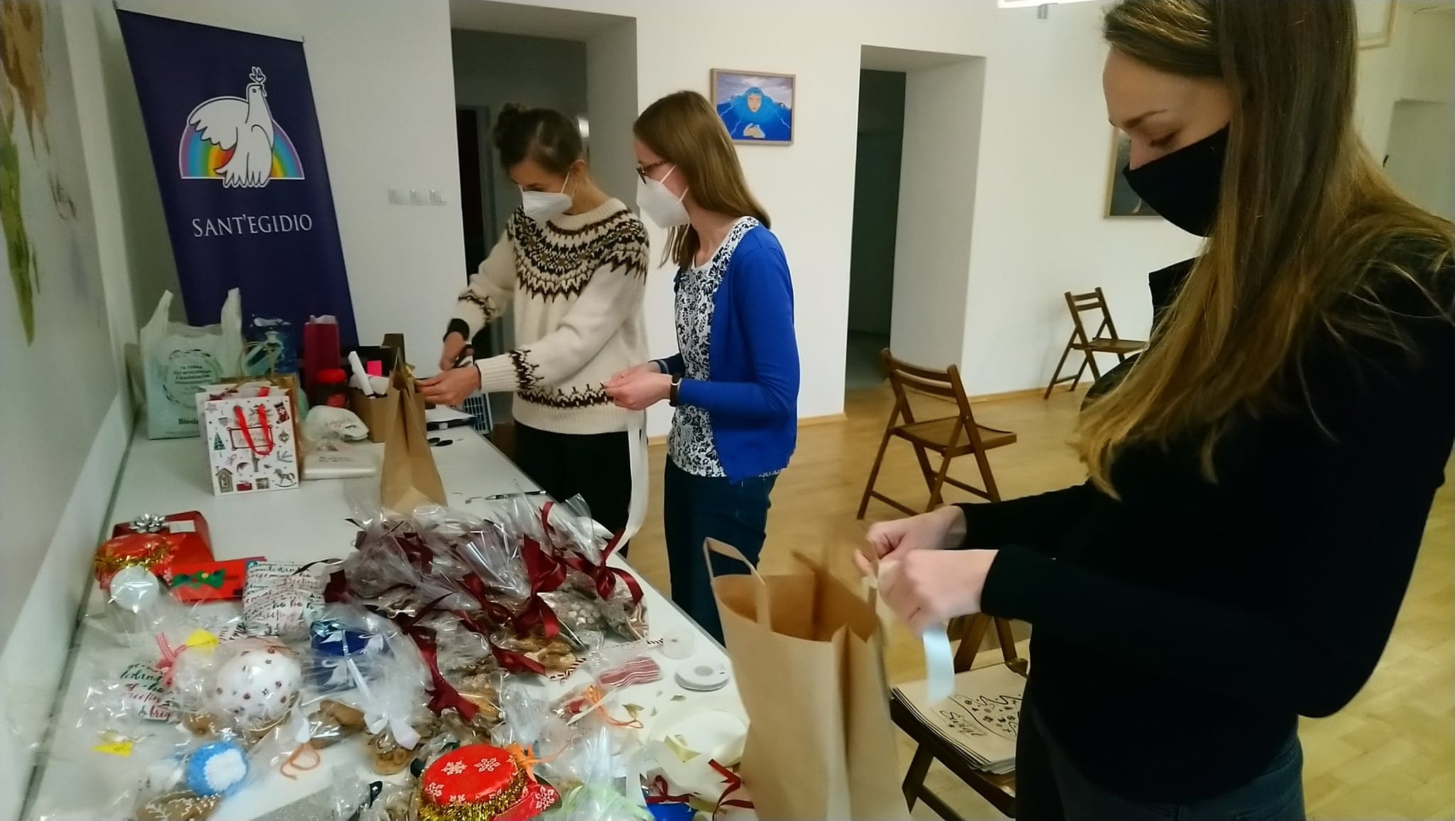 Wolontariuszki przy stole szykują torebki z podarunkami