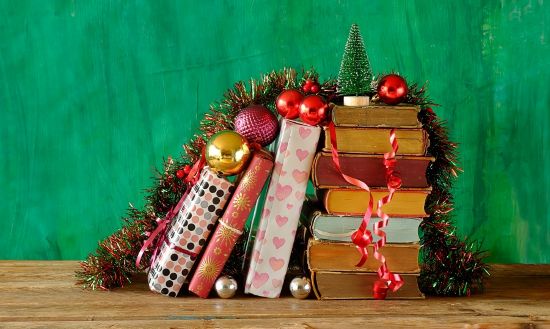 Książki zapakowane na świąteczny prezent, udekorowane bombkami i łańcuchami choinkowymi