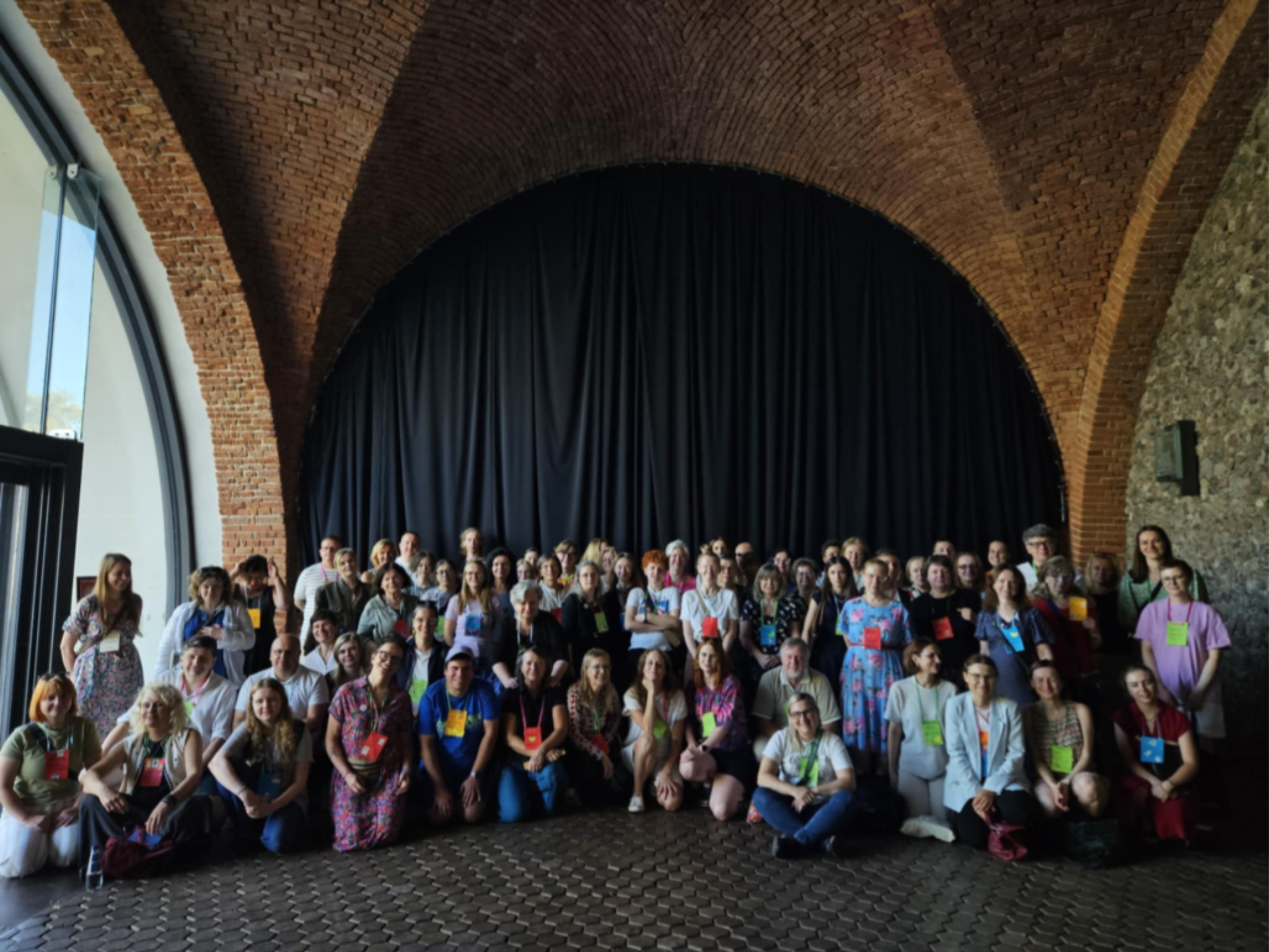 Grupowe zdjęcie wolontariuszek i wolontariuszy z warszawskich muzeów podczas wydarzenia integracyjnego w Arkadach Kubickiego. 