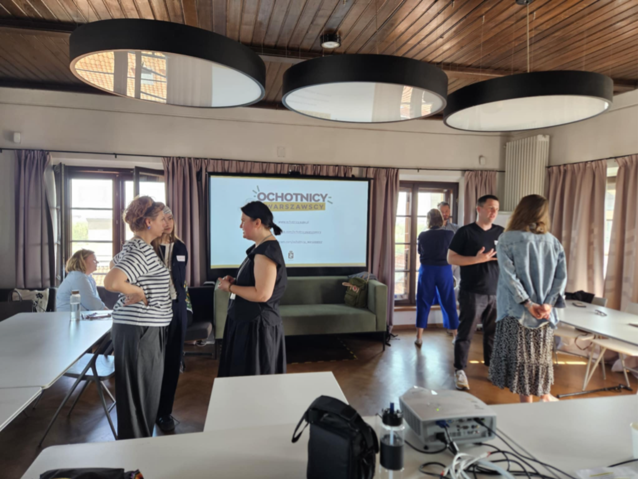 Koordynatorki i koordynatorzy wolontariatu z warszawskich muzeów rozmawiają w parach podczas spotkania Partnerstwa w sali warsztatowej Muzeum Warszawy.